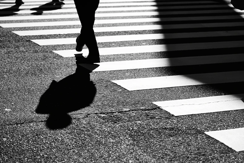 the shadow of people walking on the cross walk