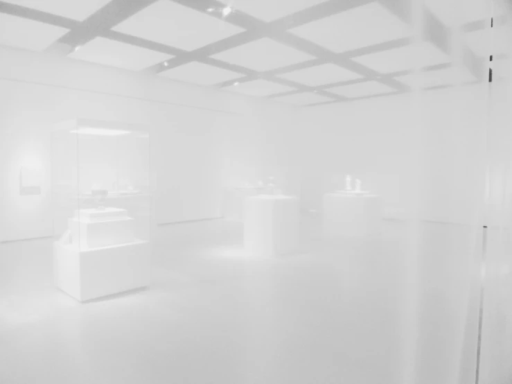 an empty white room with three benches