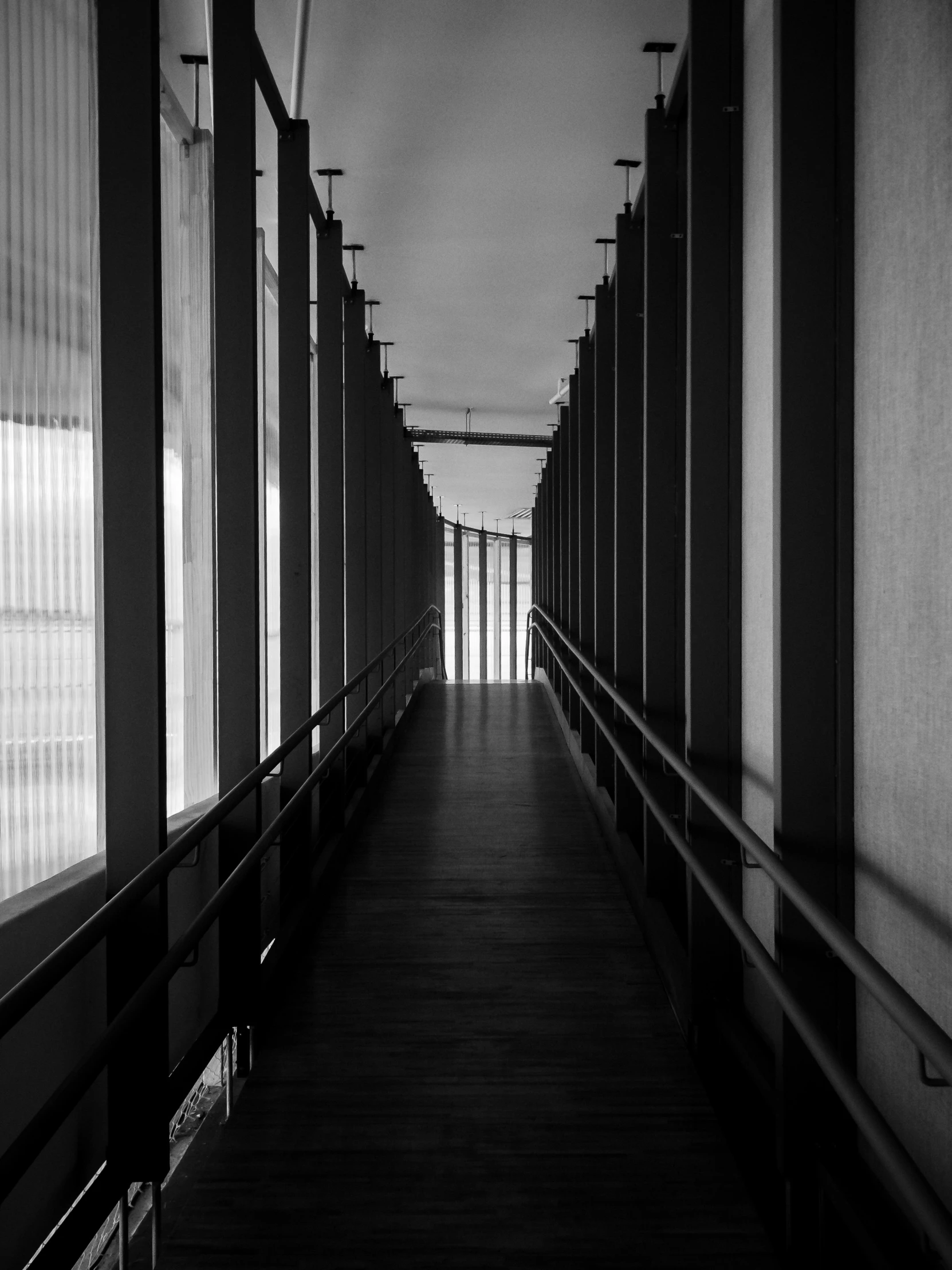 an empty walkway has lots of blinds and poles