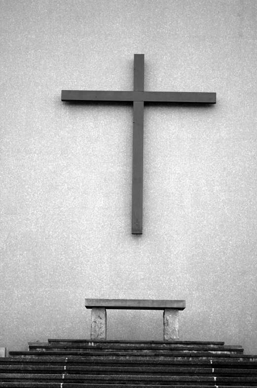 a bench in front of a large cross