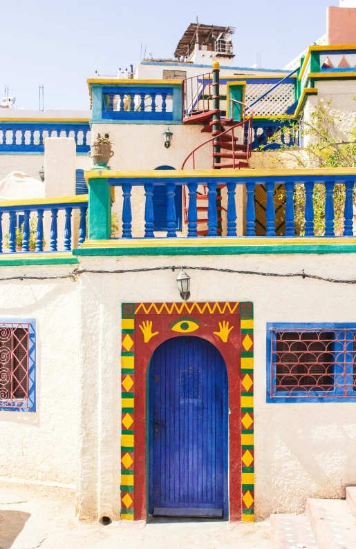 a white building with a blue door and colorful decorations