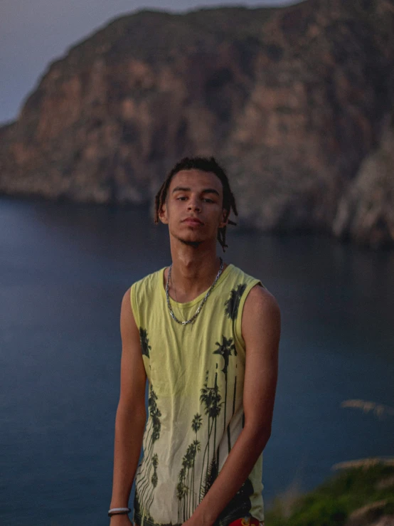 a young man poses near a large body of water