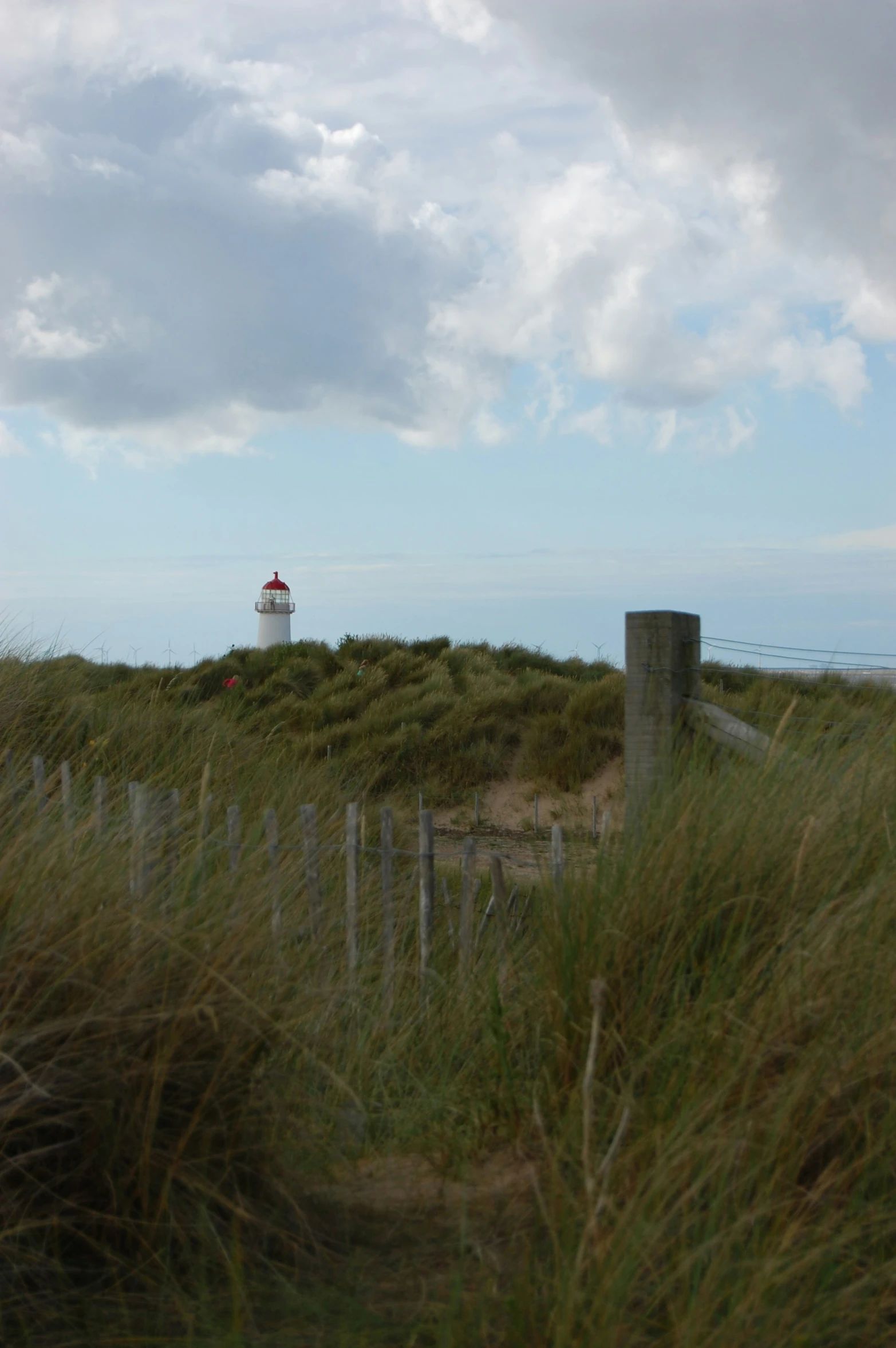 the lighthouse is sitting atop a grassy hill