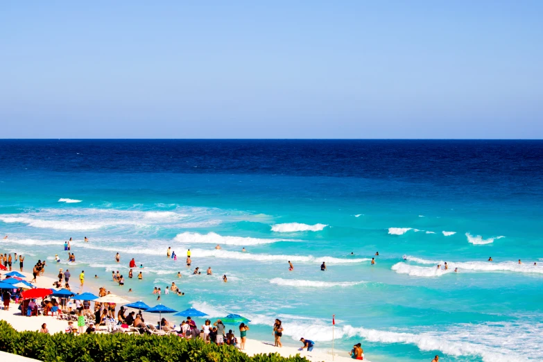 a beach full of people and umbrellas