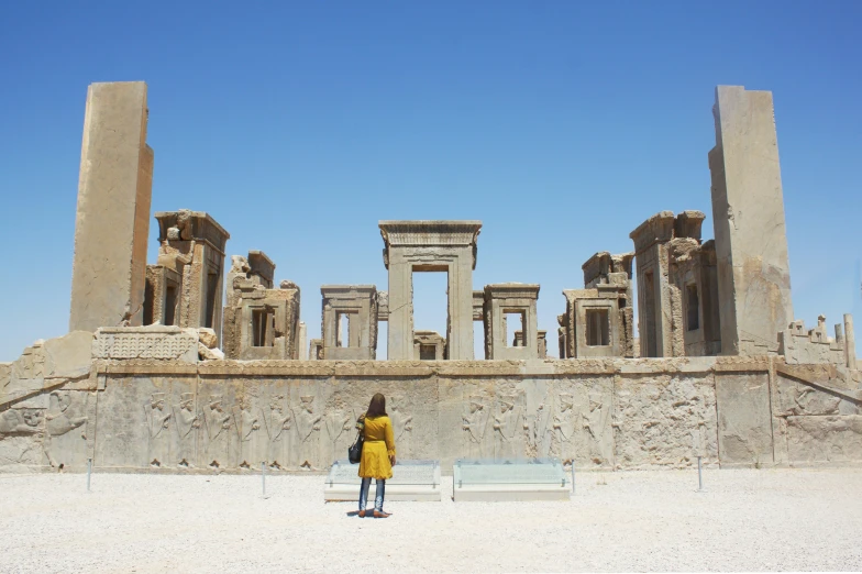 a woman standing on a bench in front of some pillars and building designs