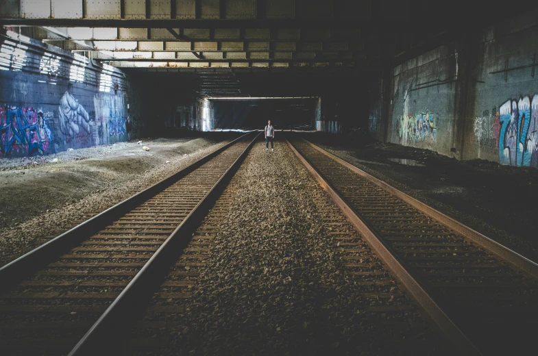 some trains on some tracks under some graffiti