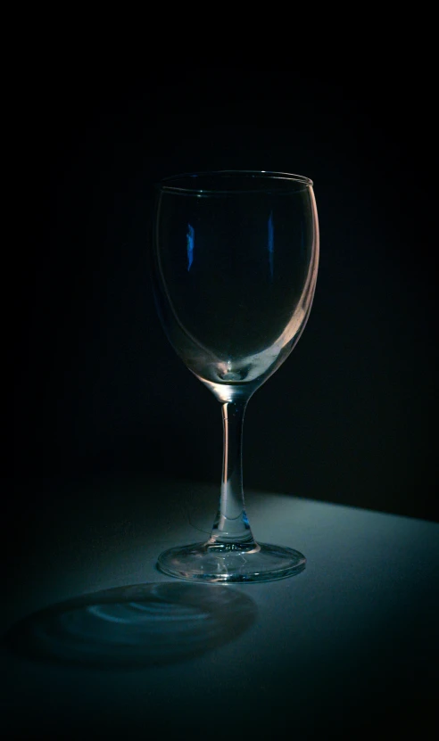 dark colored wine glass sitting on counter in dim lit room