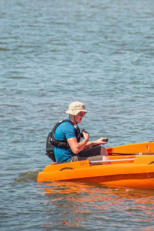 a man is sitting in a boat using his cell phone