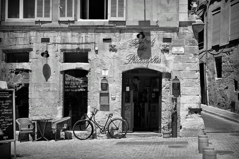 an old po of a building with a bike parked by the door