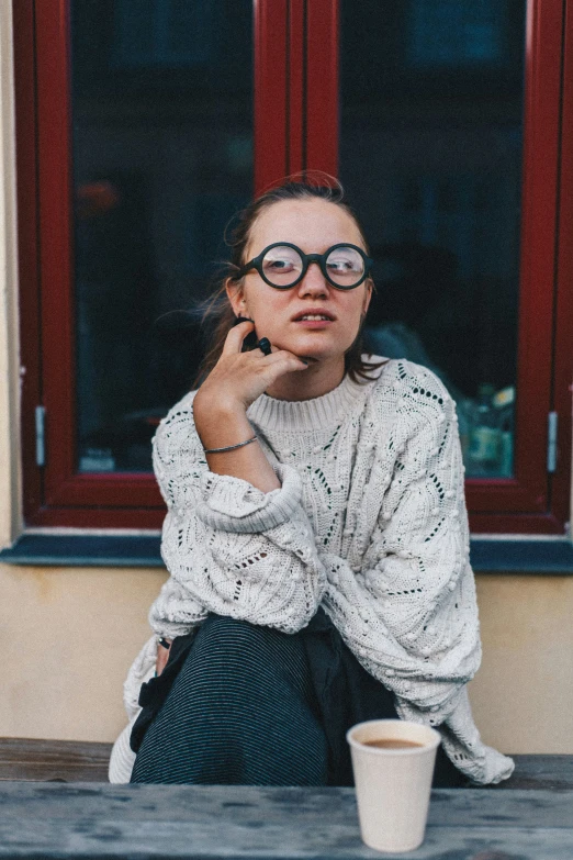 a person in glasses is sitting on a table