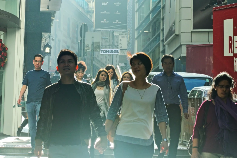 group of people walking down busy city street