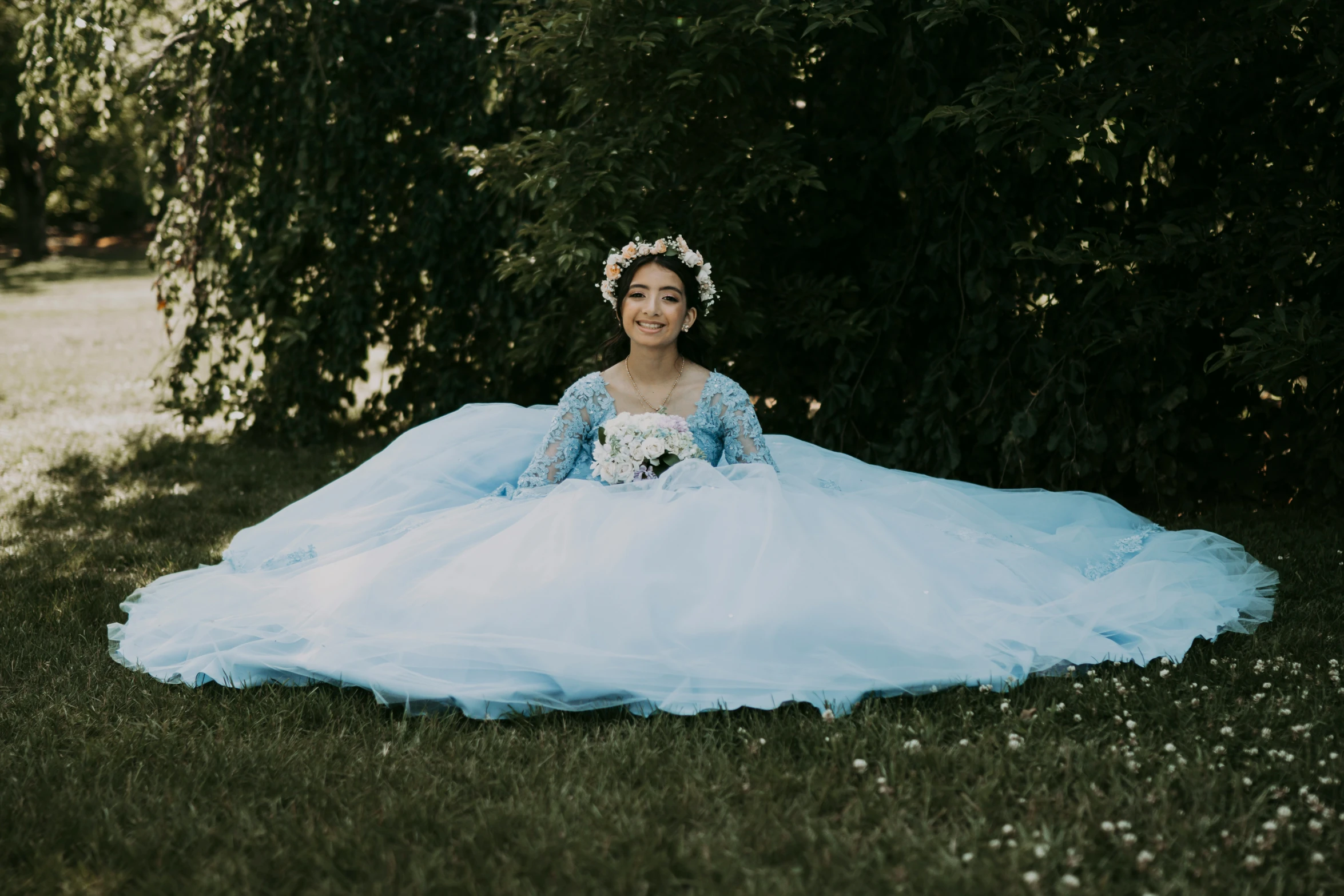 a woman wearing a dress sitting in the grass