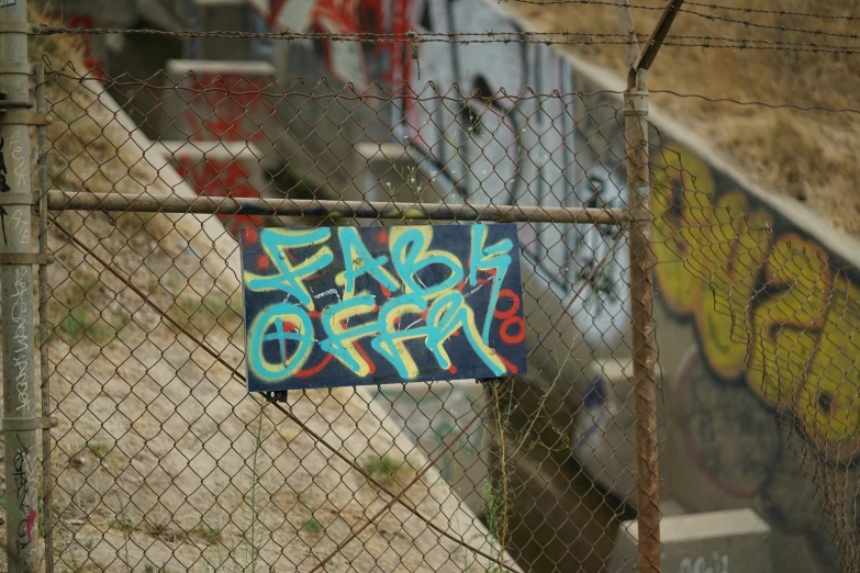 a gated in area has graffiti hanging behind it
