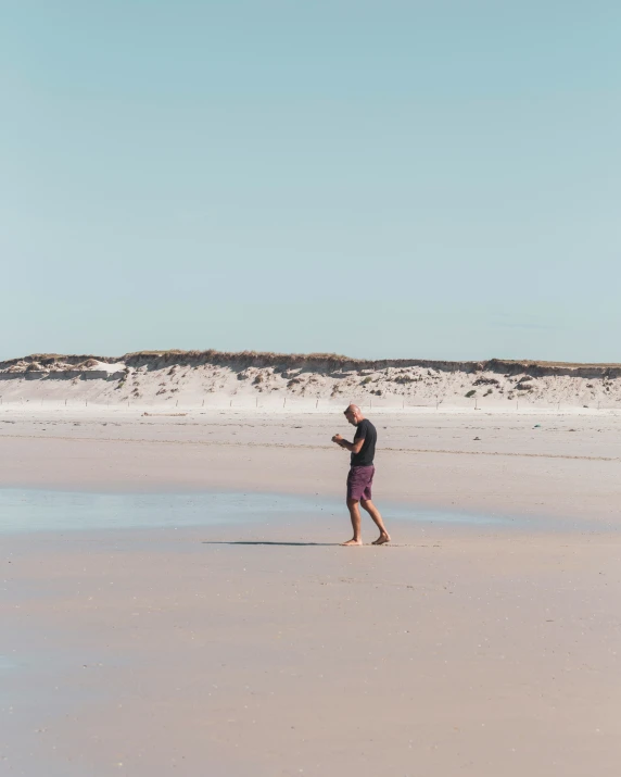 man in wet suit walking on the beach