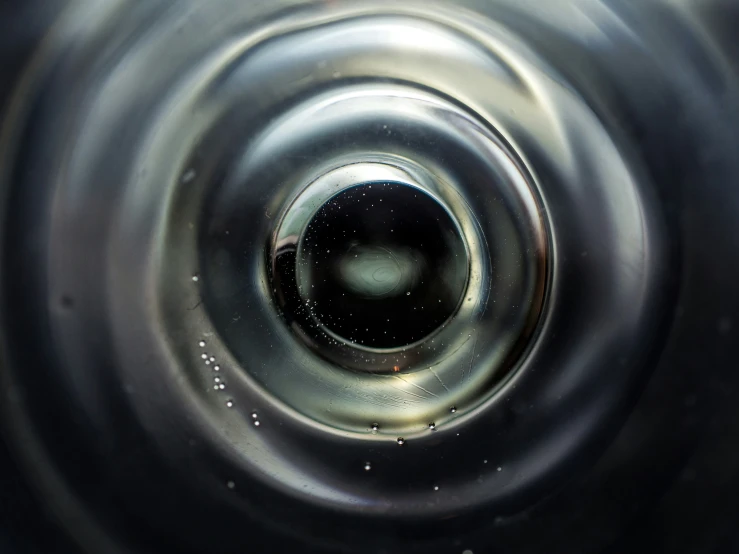 a black and silver liquid with a white circle