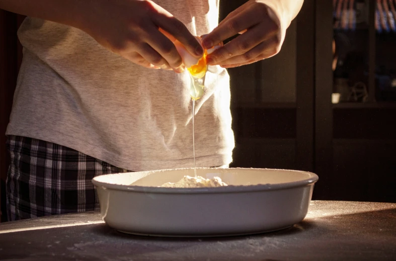 someone holding soing in their hands over a white bowl