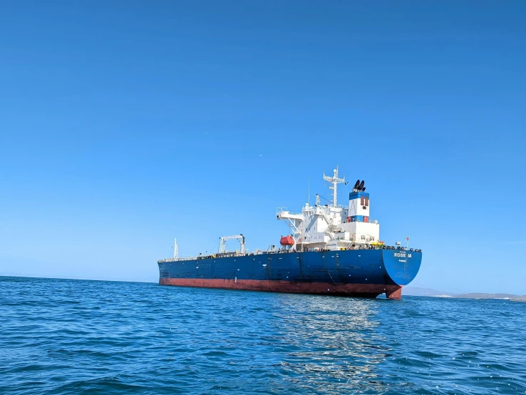 a boat floats in the ocean against a blue sky