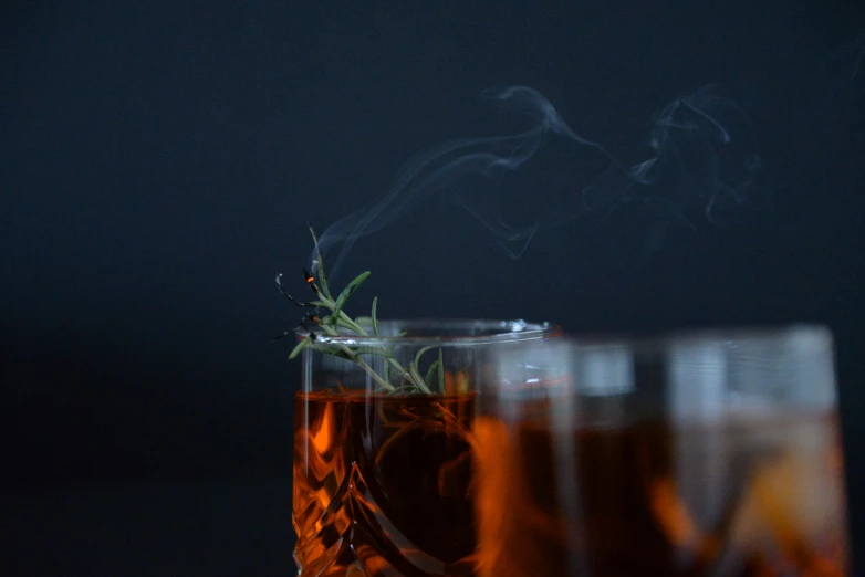 the top of two clear cups are filled with some dark beverage