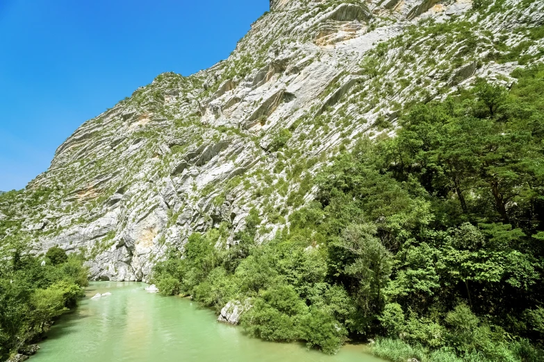 a river with green and yellow colored water is seen from the side of a mountain