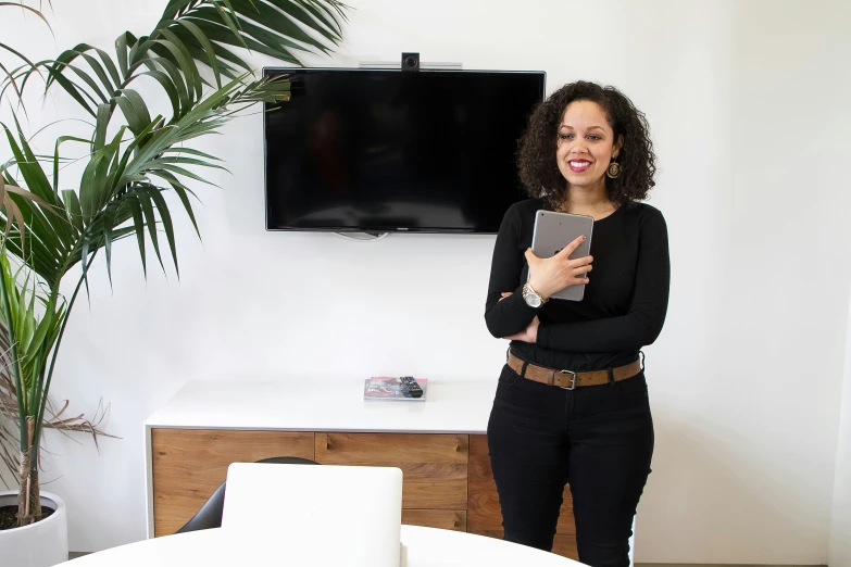 a smiling woman is standing in her living room