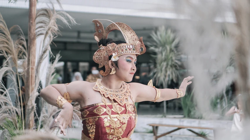 a woman wearing a costume with feathers and gold