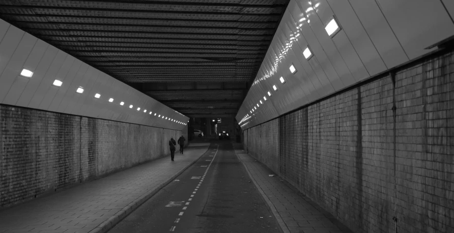 people standing in a tunnel looking at a phone