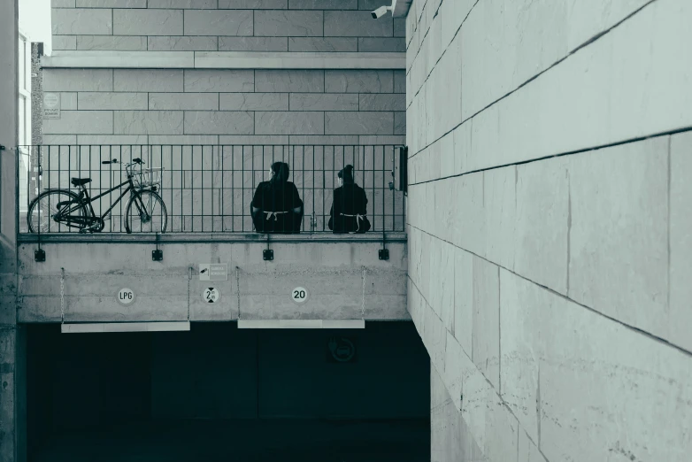 two bicycles in a bike alley near a cement wall