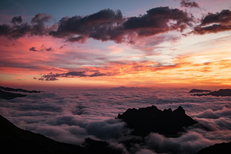 the view of clouds, mountains and rocks from top of a hill