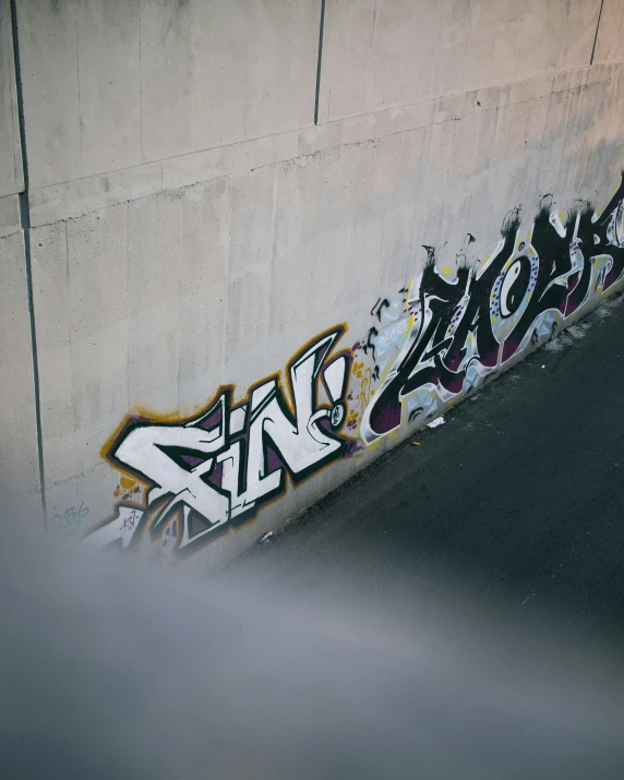 the street corner of a concrete area with graffiti on the side of it