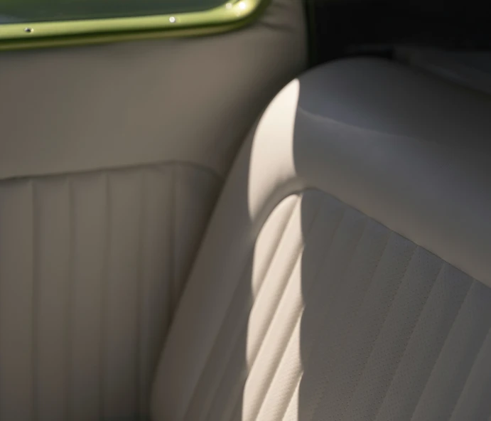 the interior of a car with light from sunlight streaming in the back window