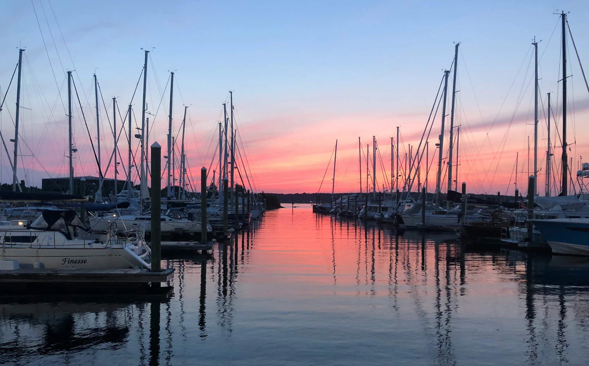 a marina filled with lots of boats during a colorful sunset