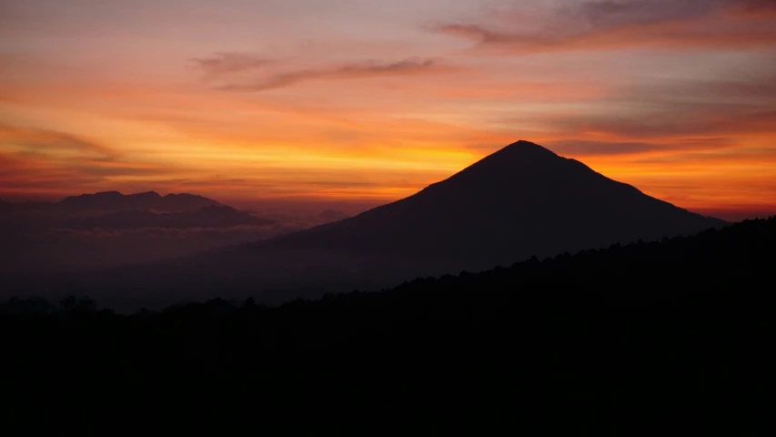 the top of a mountain is seen during sunset