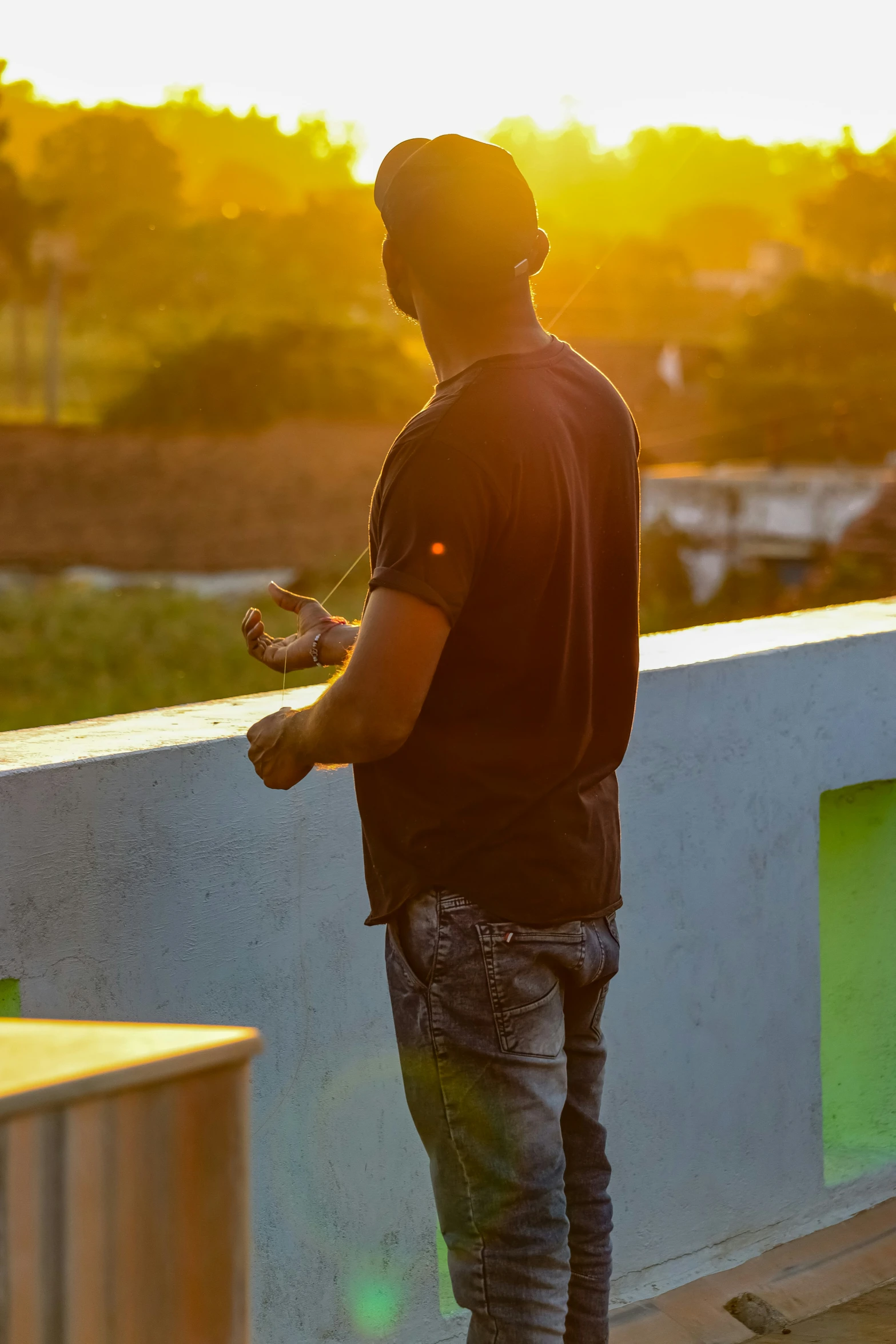 a man in a black shirt standing by the wall