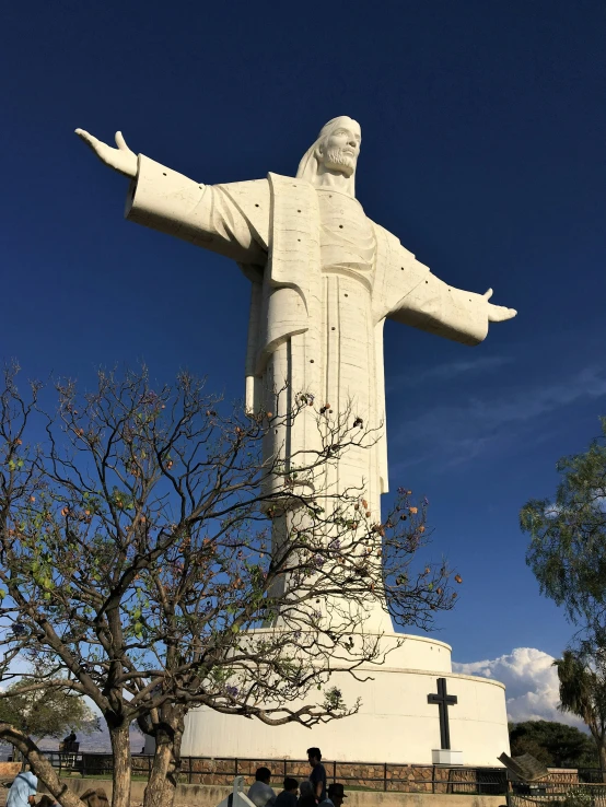 the image of people are standing near a large statue