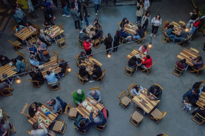 a group of people sitting at wooden tables