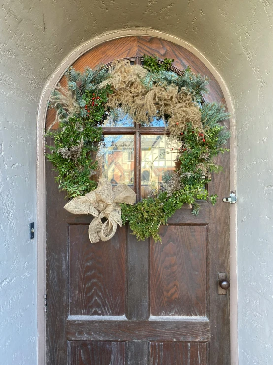 a wooden door with wreaths hanging above it