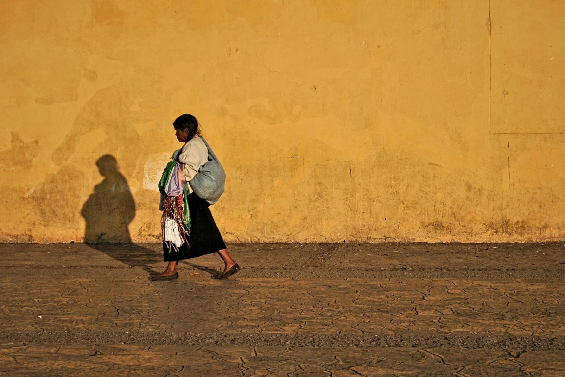 a woman with an open shirt walks down a dirty road