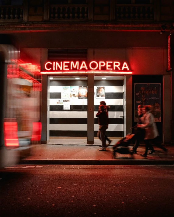 a cinema theater with lights on in a dark city