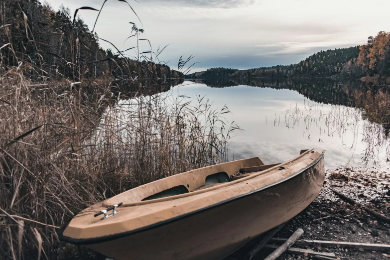 small boat on shore of small lake with trees