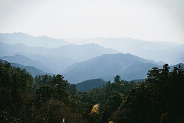 mountains with some clouds and trees at the base