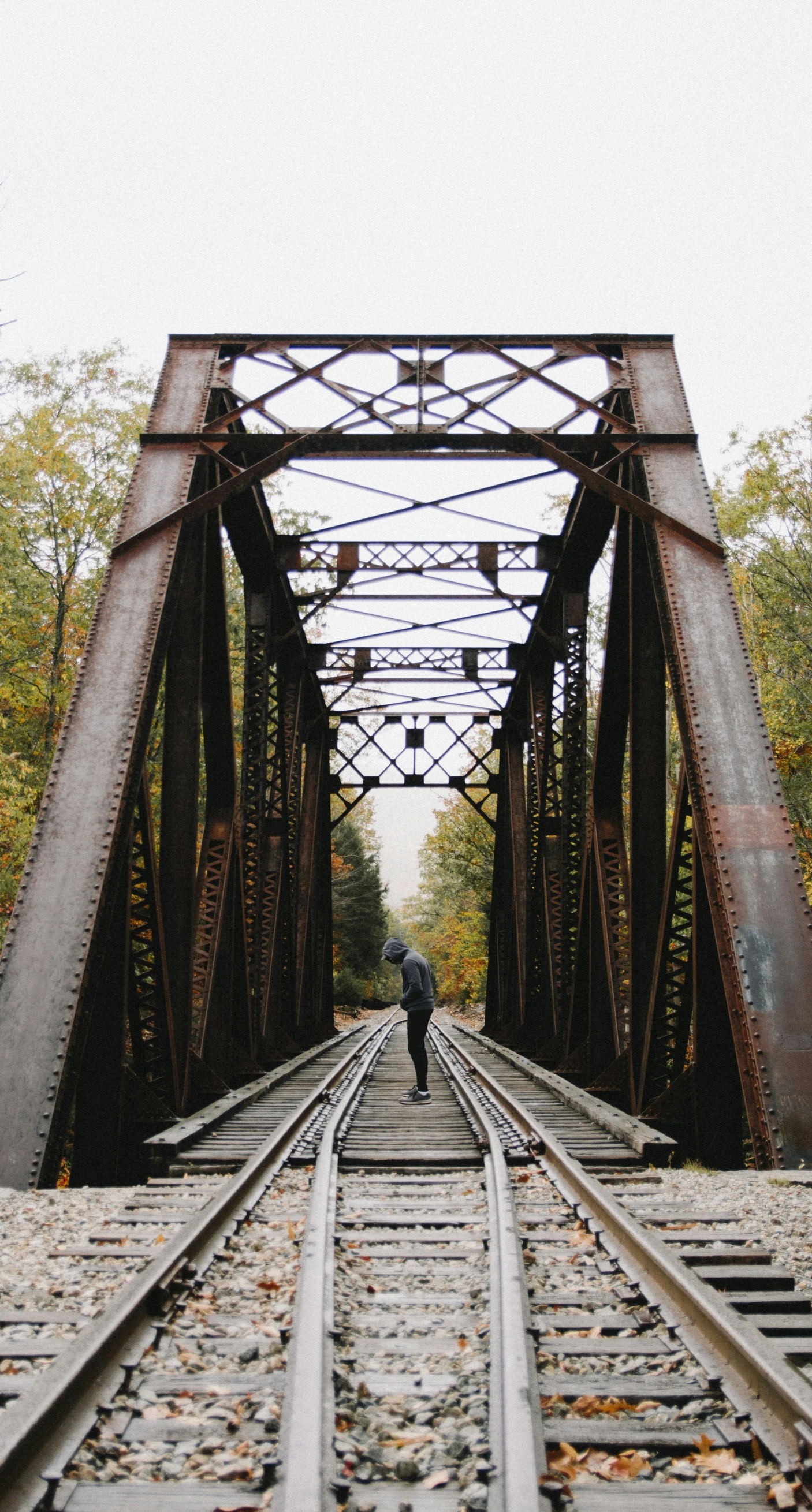 a person is walking alone on the railroad tracks