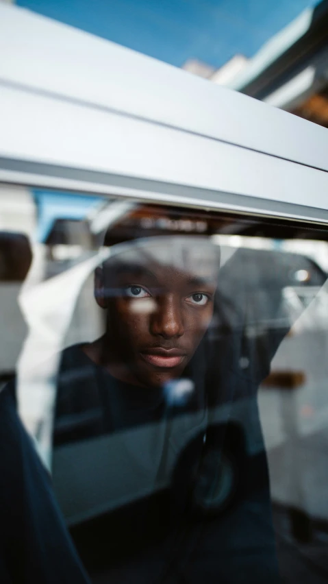 a black man sitting inside of a bus