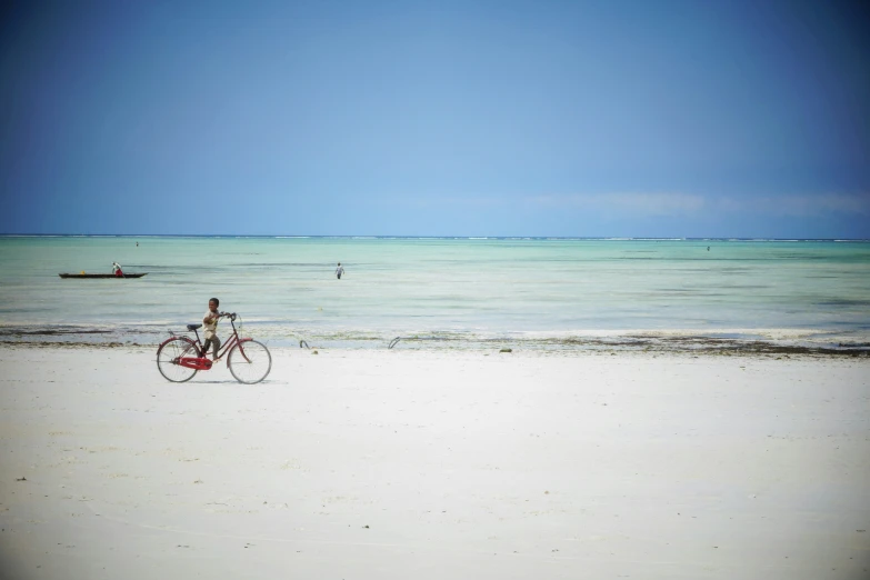 a person is riding a bike on the beach