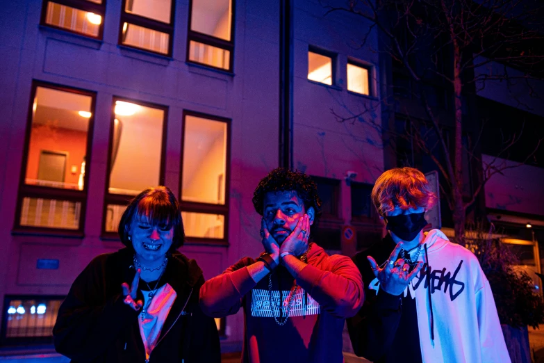 three men standing outside of a building with painted hands