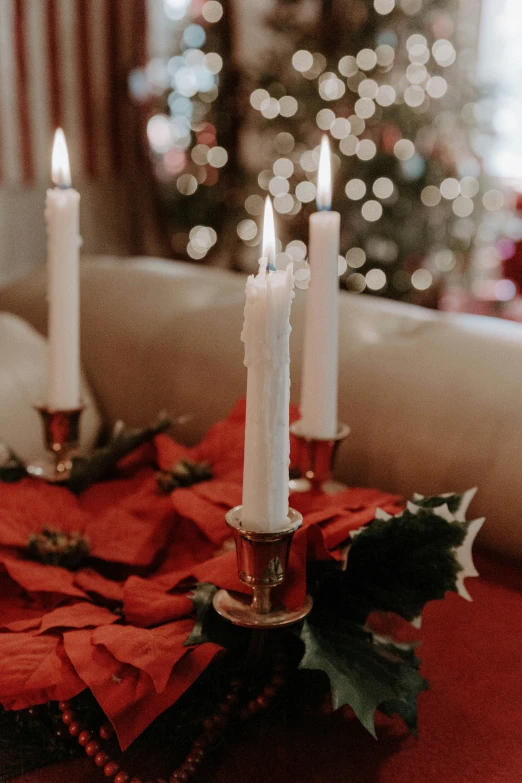 two candles and christmas decorations on a table