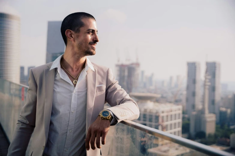 a man wearing a beige jacket looks out over a city