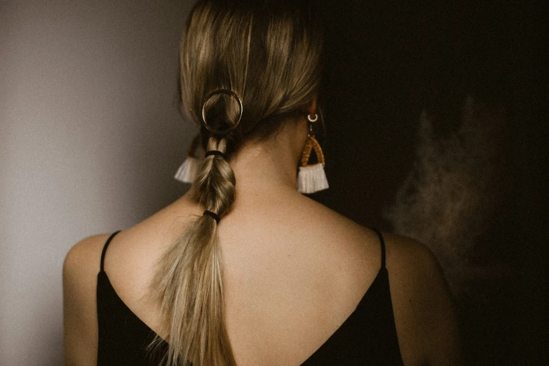 a close - up po of a woman with her hair in a pony tail id