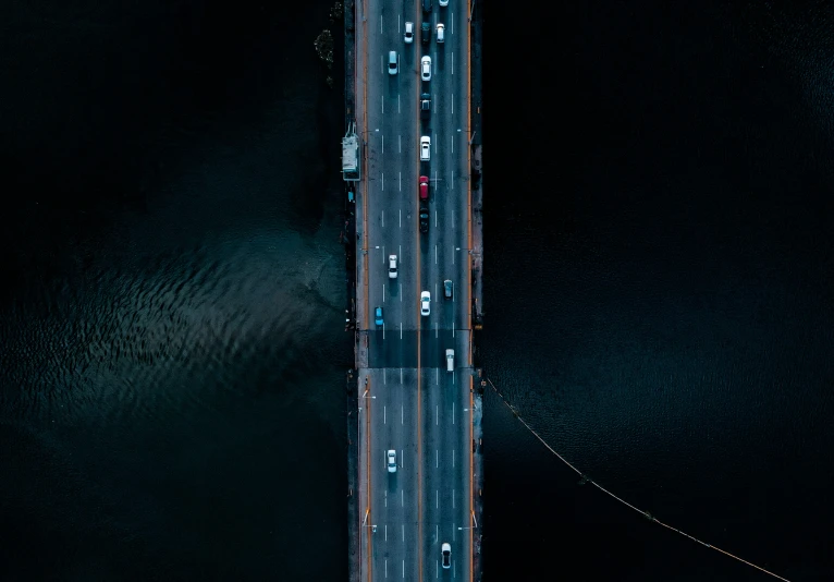 a bridge over some water with lots of cars