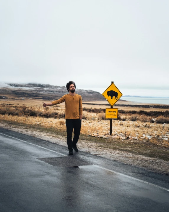 a man on the side of a road holding out his arm