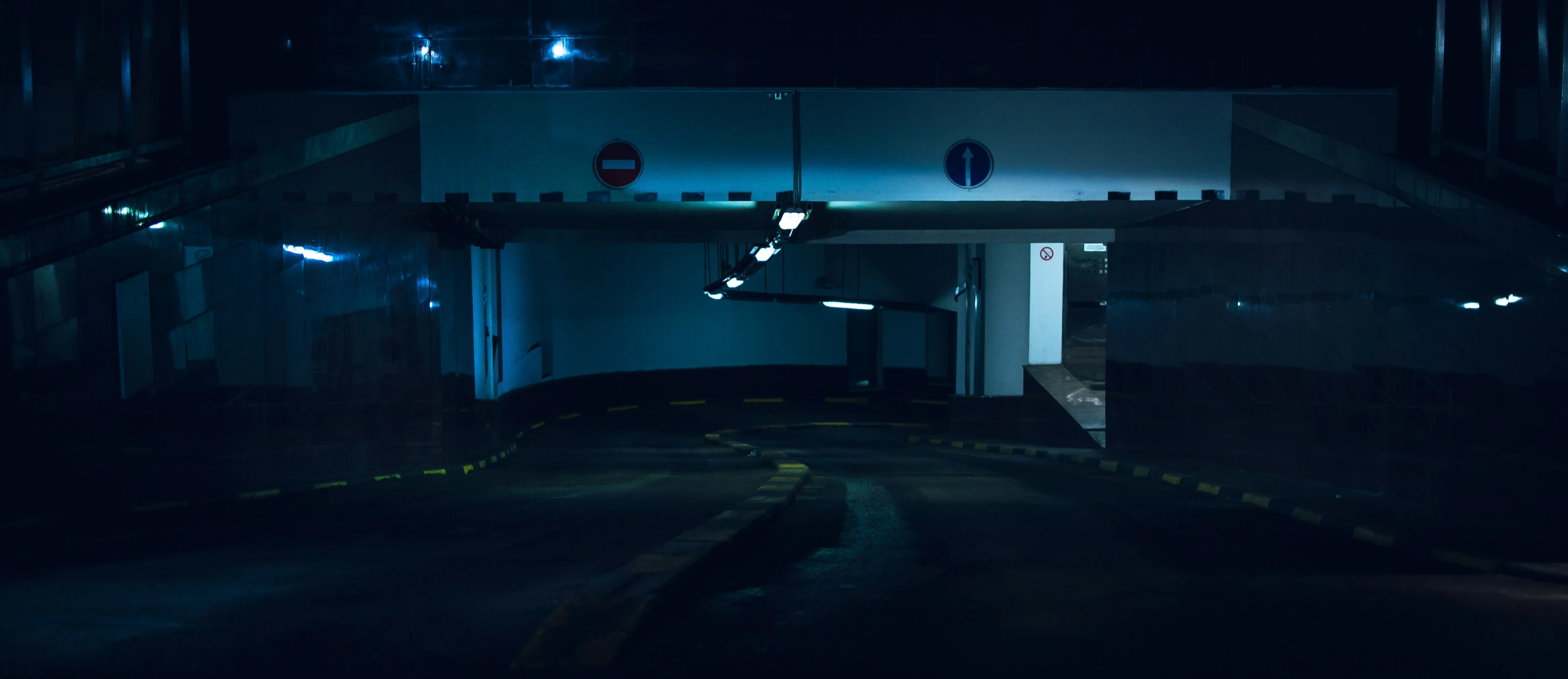 a dark building with a no parking sign in it